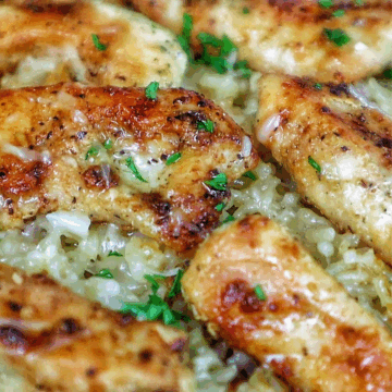 Golden brown seasoned chicken tenders on a bed of creamy garlic Parmesan rice, garnished with fresh parsley and parmesan cheese.