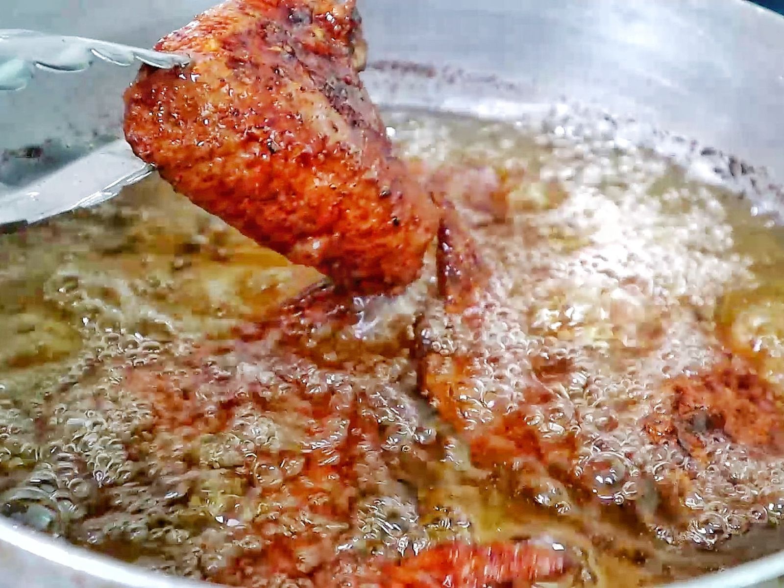 Crispy, golden-brown Chinese-style chicken wings fresh from frying and packed with seasoned flavor.