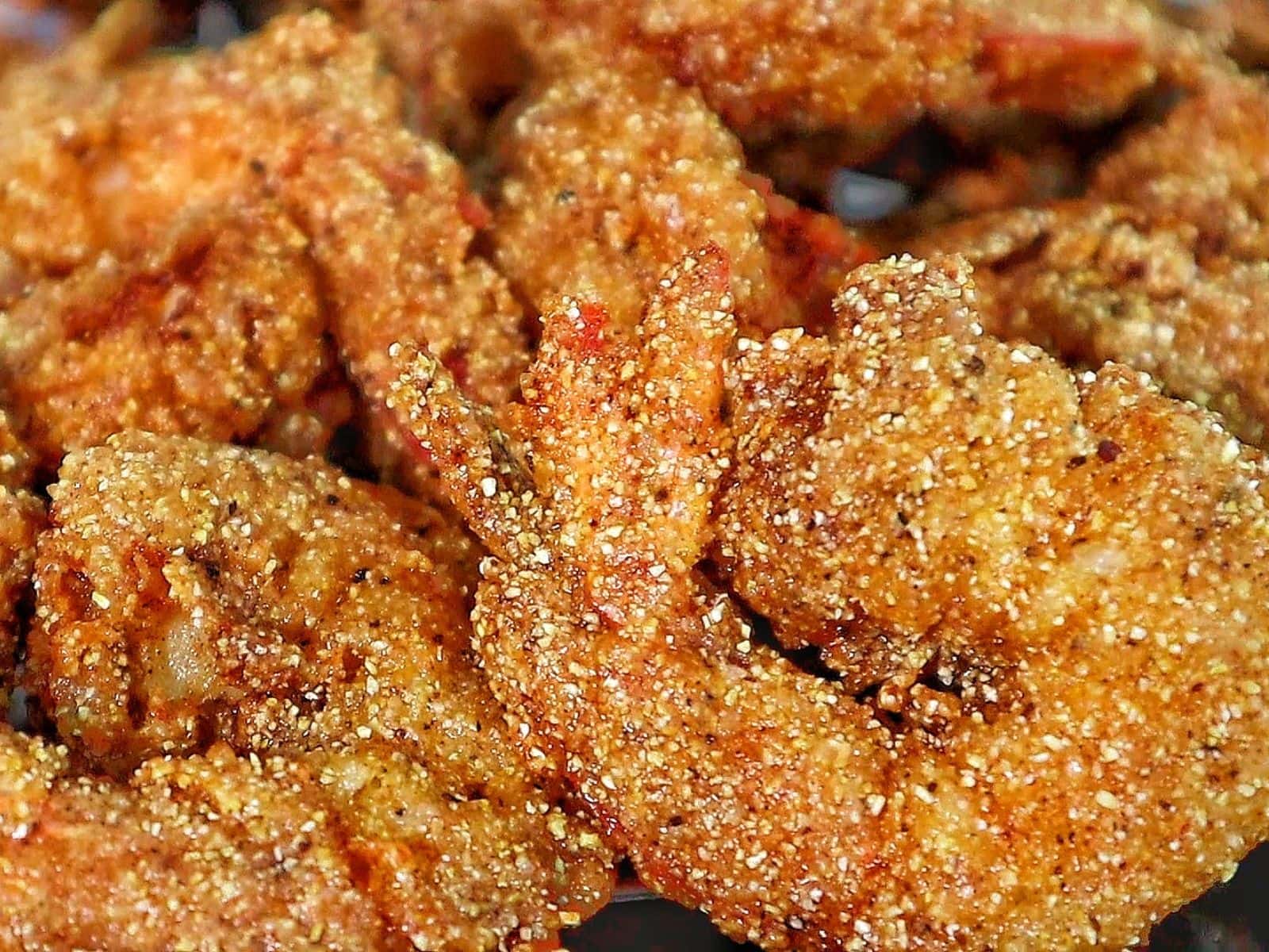 Golden, crispy Creole-seasoned fried shrimp, showcasing a crunchy cornmeal coating and deep-fried perfection.

