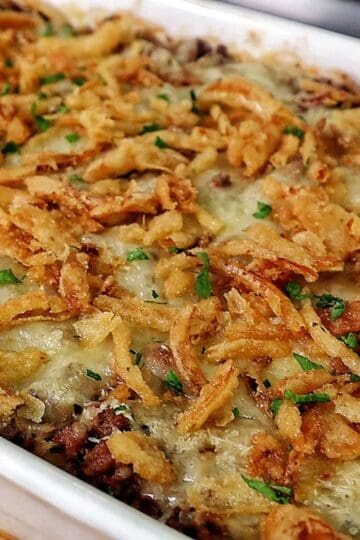 A close-up of a spoonful of French Onion Ground Beef and Rice Casserole, featuring tender ground beef, cooked rice, melted Swiss cheese, and crispy fried onions.