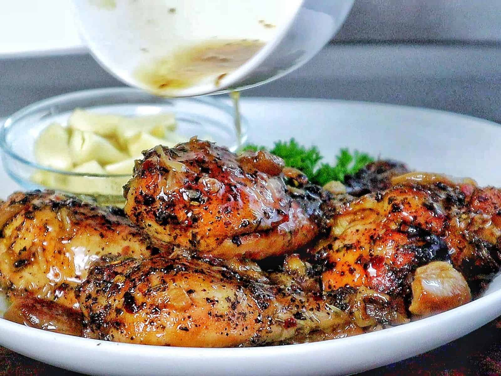 Golden brown, slow-cooked Italian garlic chicken thighs in savory juices, served with tender garlic cloves.