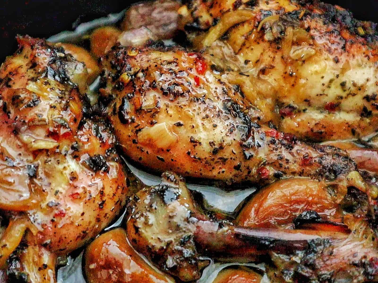 Golden brown, slow-cooked Italian garlic chicken thighs in savory juices, served with tender garlic cloves.