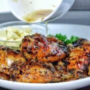 Golden brown, slow-cooked Italian garlic chicken thighs in savory juices, served with tender garlic cloves.