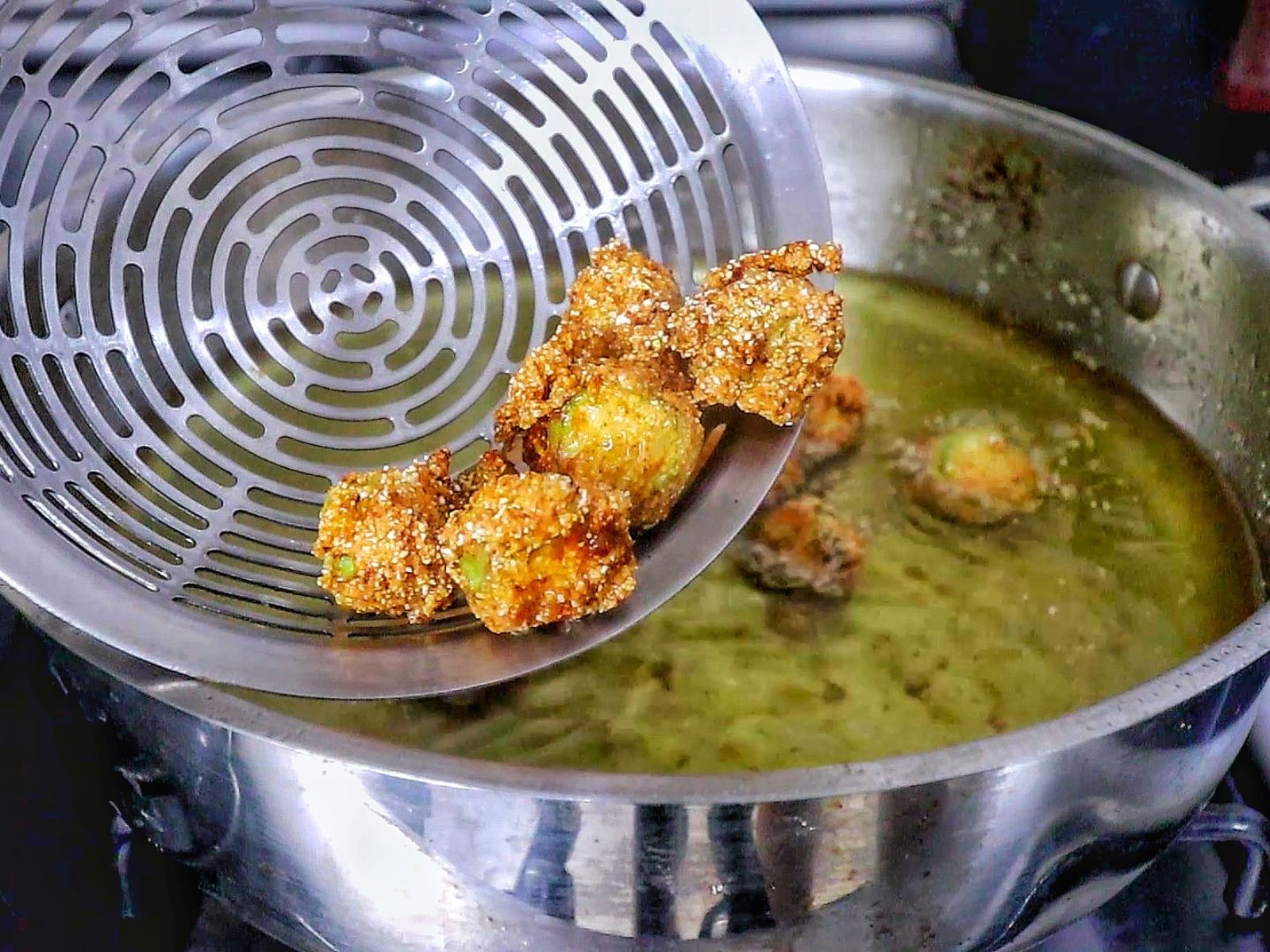 Golden brown Southern fried okra on a wire rack, crispy and seasoned with a cornmeal crust.