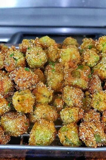 Golden brown Southern fried okra on a wire rack, crispy and seasoned with a cornmeal crust.
