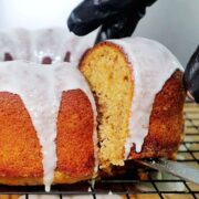 A moist sweet potato bundt cake topped with a smooth vanilla glaze, dripping down the sides.