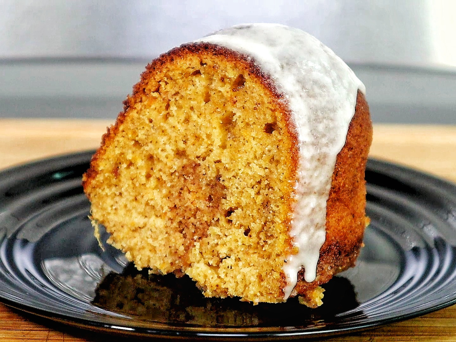 A moist sweet potato bundt cake topped with a smooth vanilla glaze, dripping down the sides. 