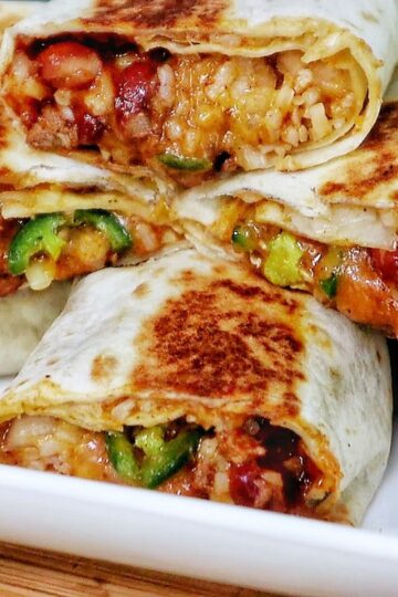 A stack of grilled chili cheese burritos, stuffed with seasoned ground beef, melted cheese, rice, beans, and sliced jalapeños.