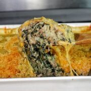creamy ground beef and spinach casserole in a baking dish, with gooey melted cheese stretching and a golden, crispy topping.