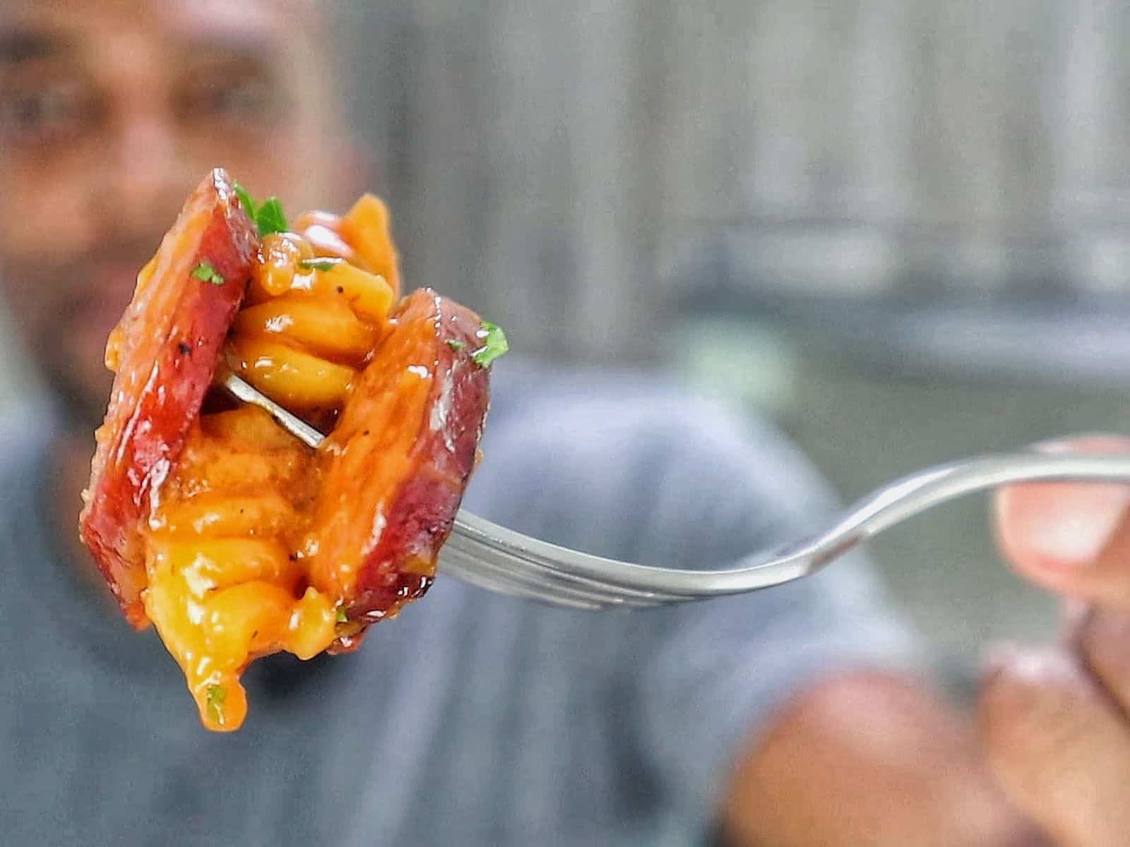 rotini pasta coated in a rich honey BBQ sauce with sliced sausage and garnished with fresh parsley