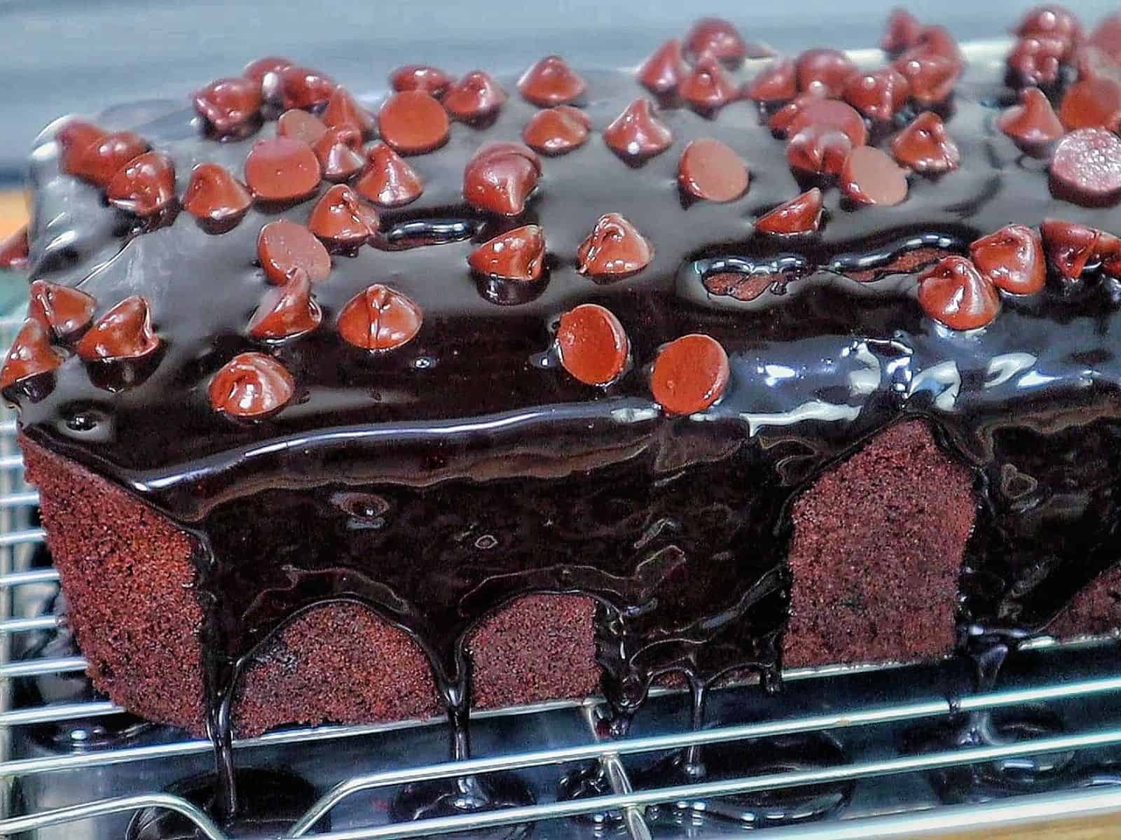 A rich, fudgy loaf of brownie bread topped with hot fudge and a sprinkle of chocolate chips.