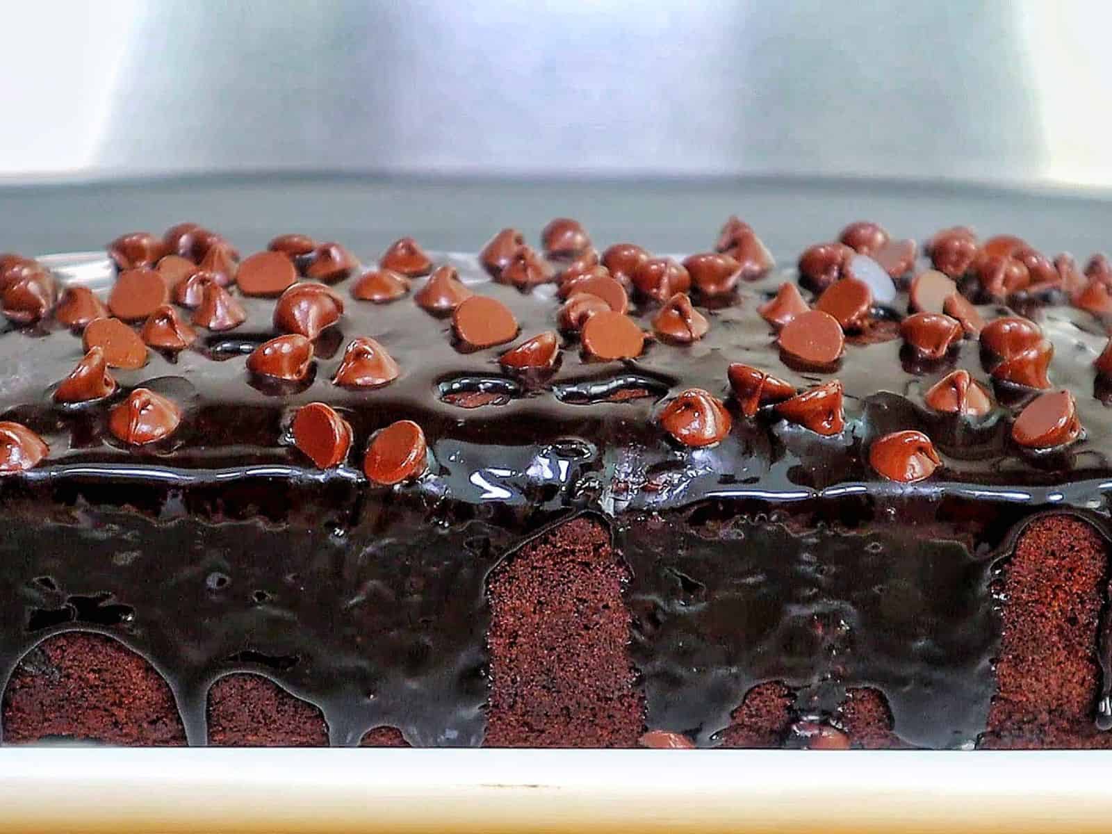 A rich, fudgy loaf of brownie bread topped with hot fudge and a sprinkle of chocolate chips.