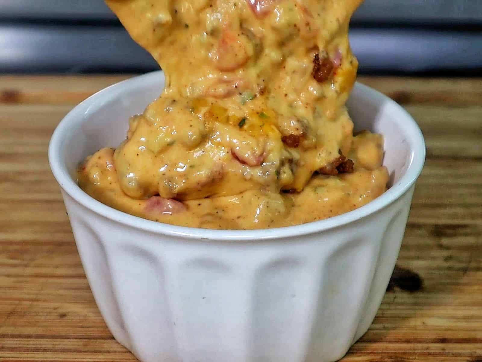 Creamy Ranch Rotel queso dip topped with browned sausage crumbles and garnished with fresh chopped parsley.