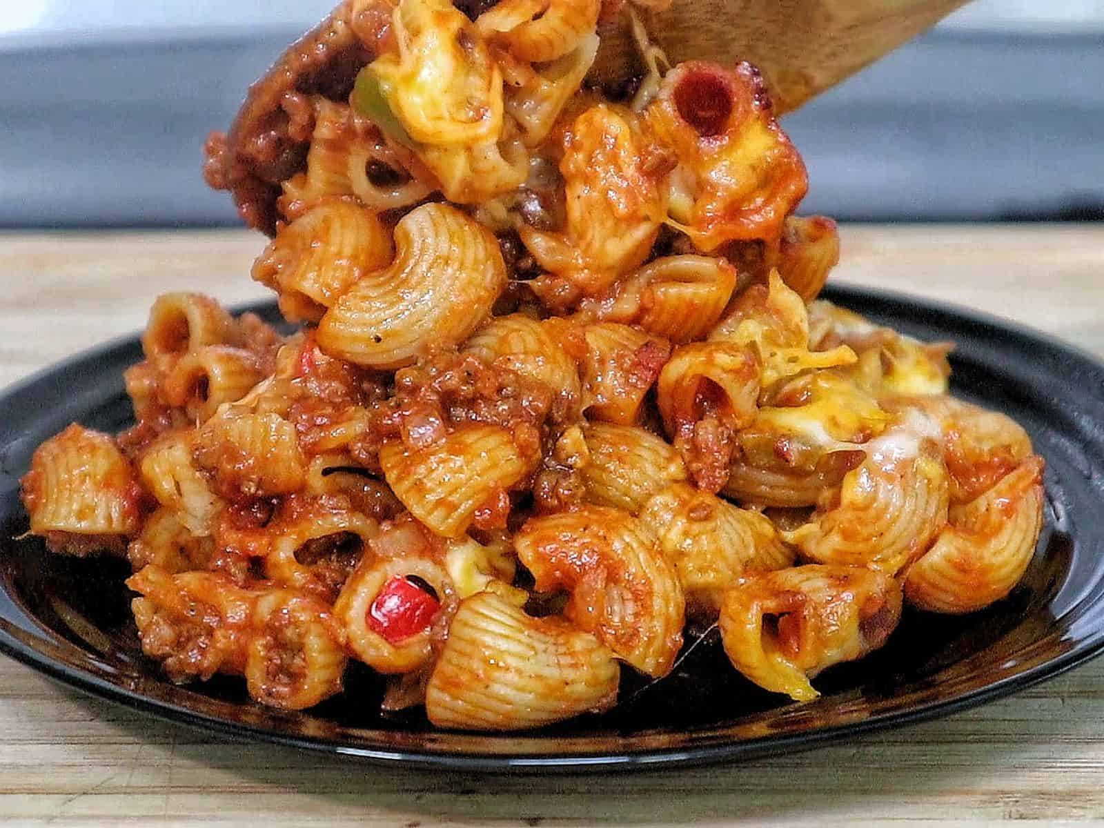 Baked sloppy joe casserole, topped with melted cheddar and mozzarella cheese, bubbling and golden brown.