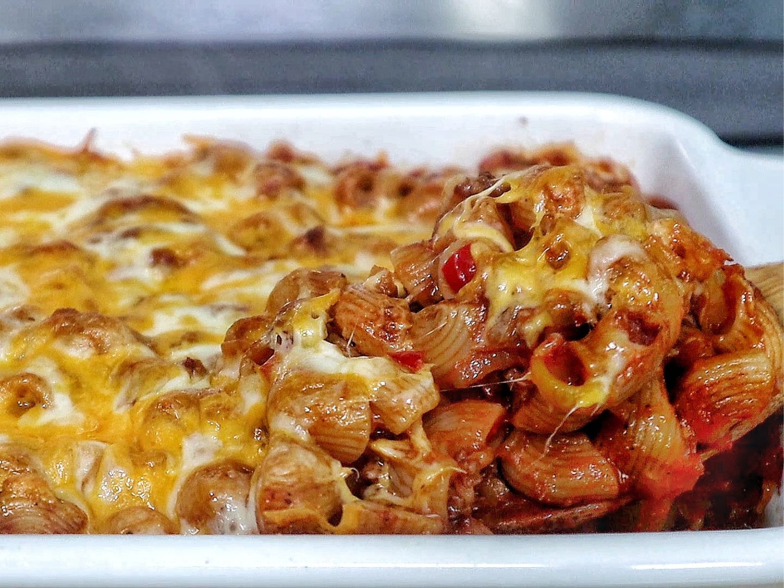 Baked sloppy joe casserole, topped with melted cheddar and mozzarella cheese, bubbling and golden brown.