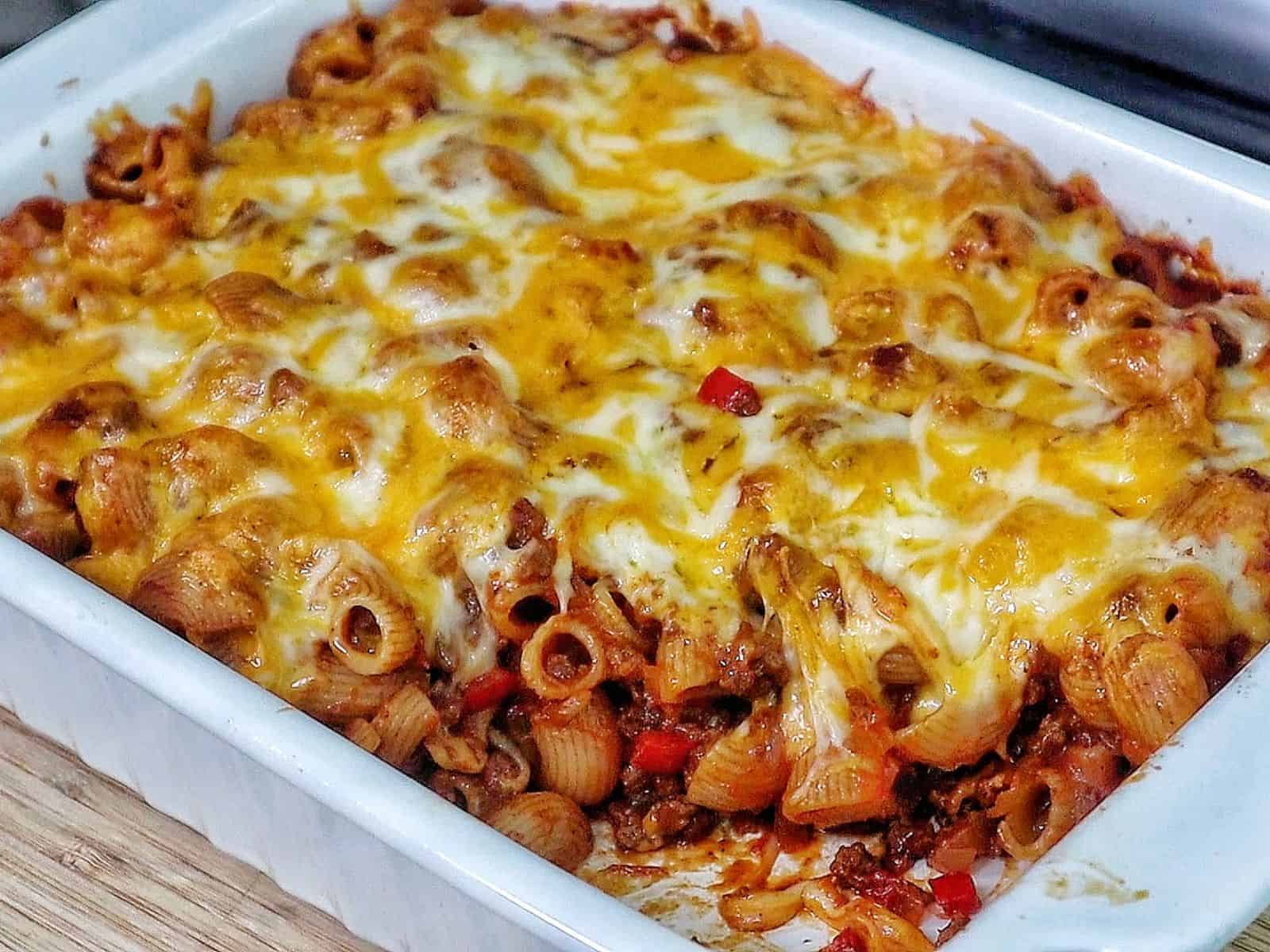 Baked sloppy joe casserole, topped with melted cheddar and mozzarella cheese, bubbling and golden brown.