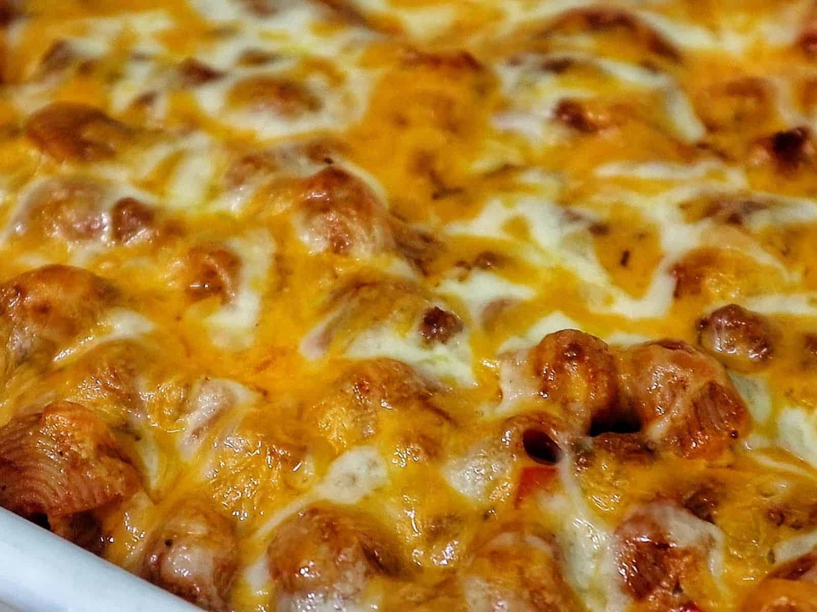 Baked sloppy joe casserole, topped with melted cheddar and mozzarella cheese, bubbling and golden brown.