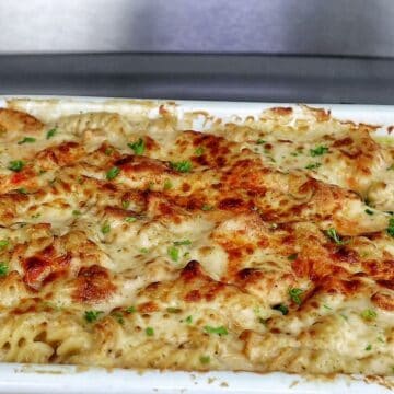 golden-brown baked garlic parmesan chicken pasta, topped with bubbly melted cheese and garnished with fresh parsley