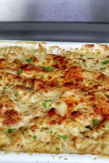 golden-brown baked garlic parmesan chicken pasta, topped with bubbly melted cheese and garnished with fresh parsley