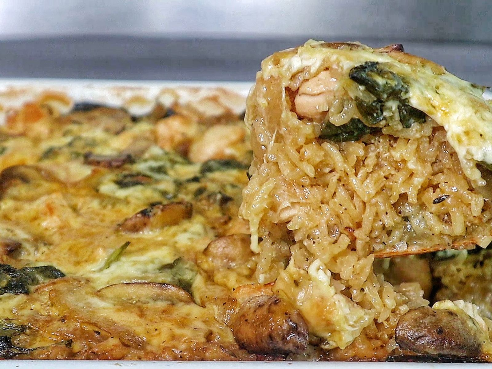 French Onion Chicken and Rice casserole with melted cheese, mushrooms, spinach, and tender chicken pieces baked together in a creamy rice mixture.