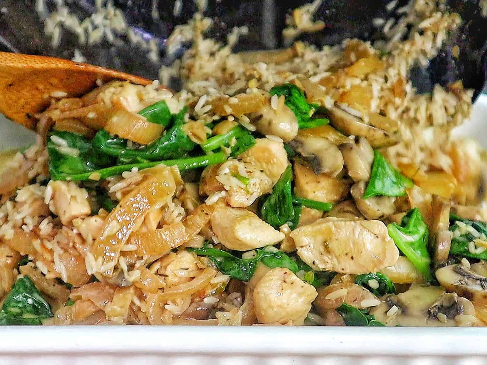 French Onion Chicken and Rice casserole with melted cheese, mushrooms, spinach, and tender chicken pieces baked together in a creamy rice mixture.