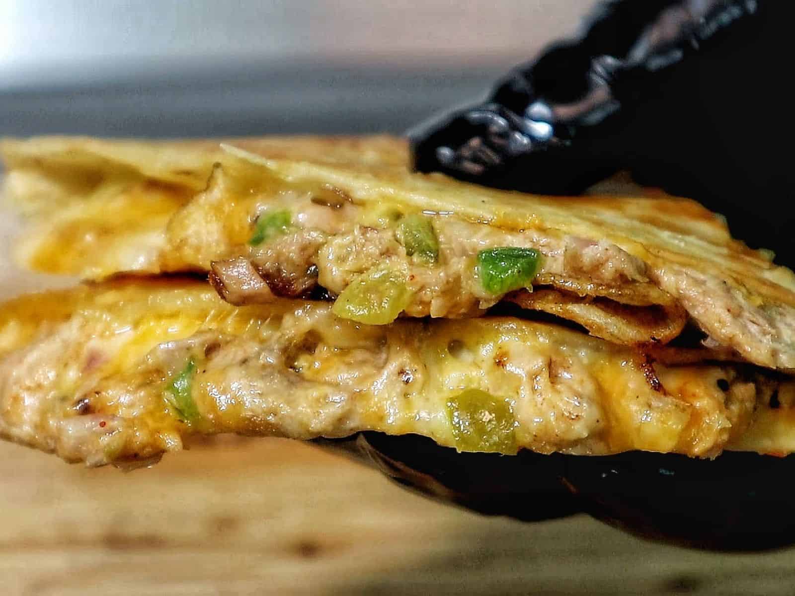 Golden brown tuna melt quesadilla, filled with melted cheese, tuna, and onions.