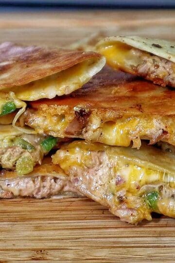 Golden brown tuna melt quesadilla, filled with melted cheese, tuna, and onions.