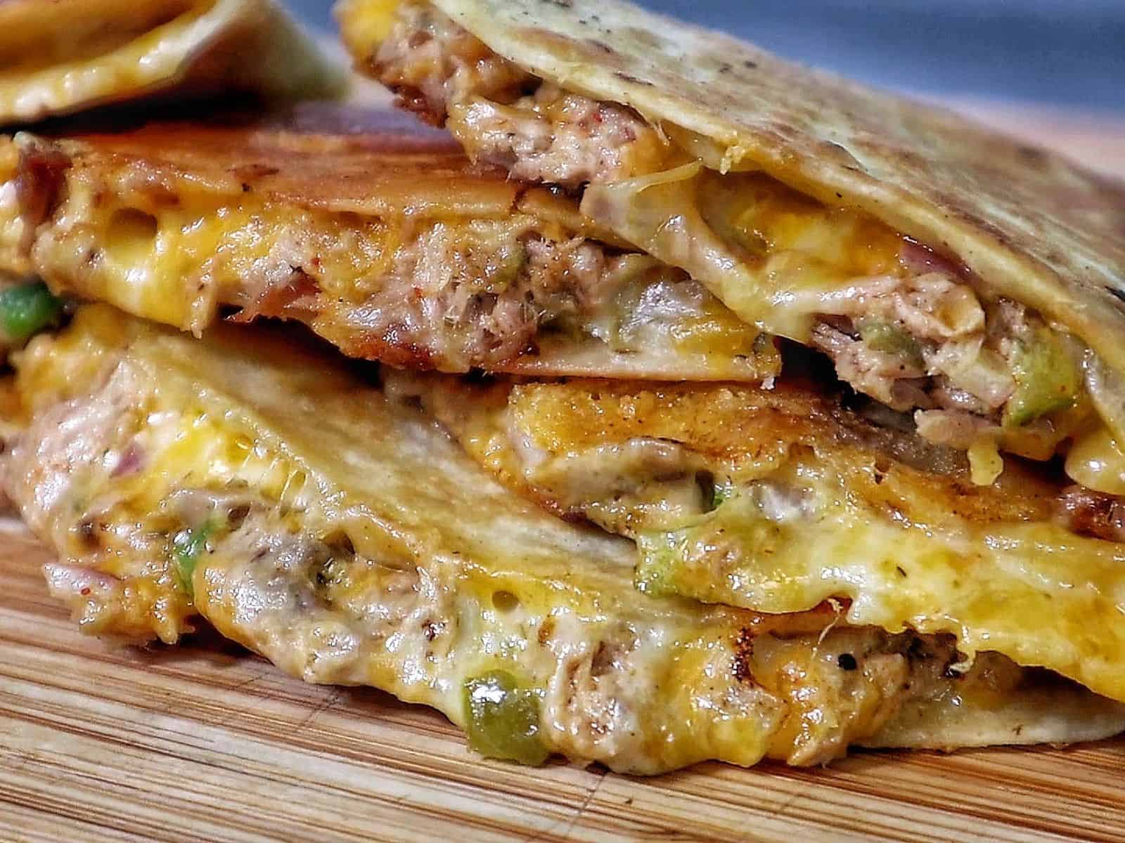 Golden brown tuna melt quesadilla, filled with melted cheese, tuna, and onions.