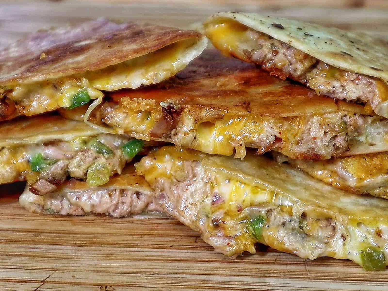Golden brown tuna melt quesadilla, filled with melted cheese, tuna, and onions.