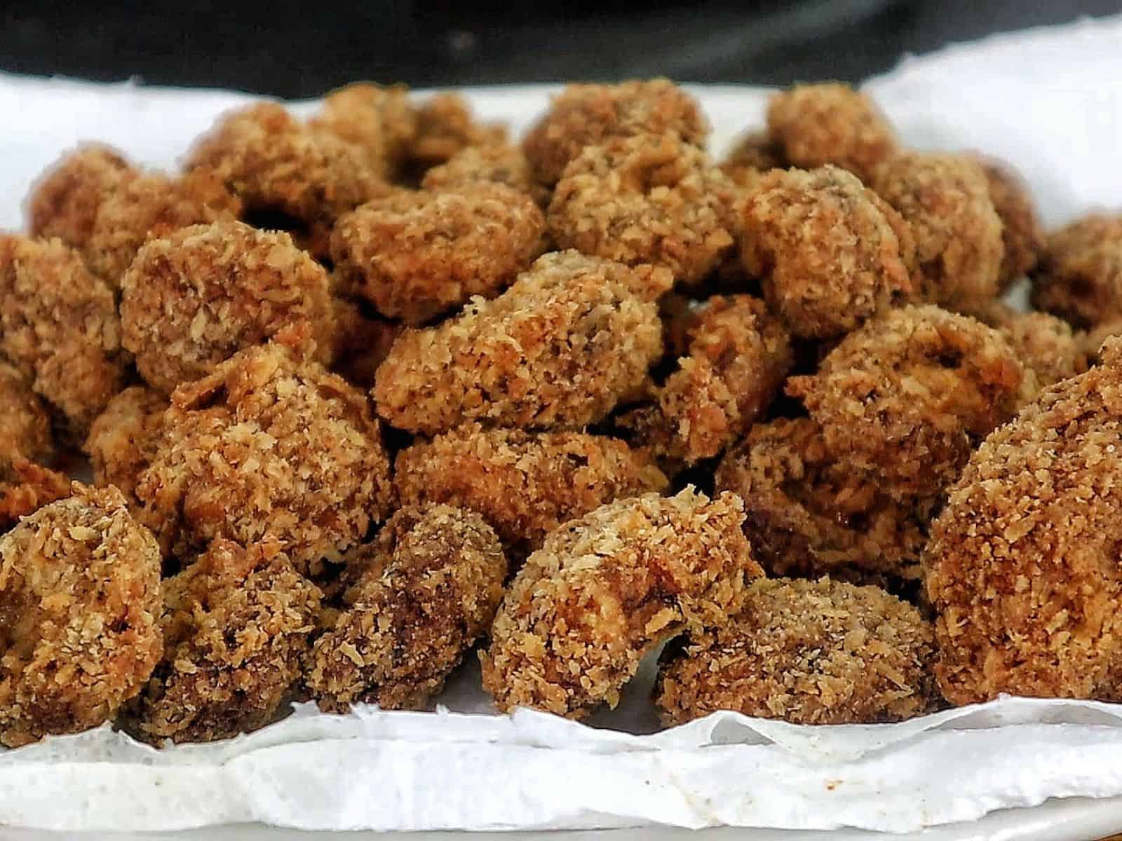 Golden, crispy Spicy Fried Mushrooms piled high, showing their crunchy coating and perfectly fried texture.