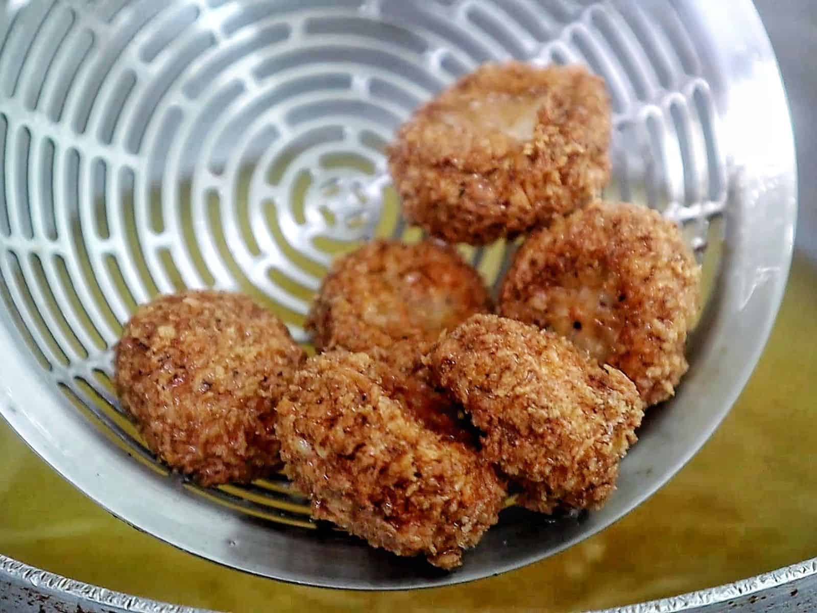 Golden, crispy Spicy Fried Mushrooms piled high, showing their crunchy coating and perfectly fried texture.
