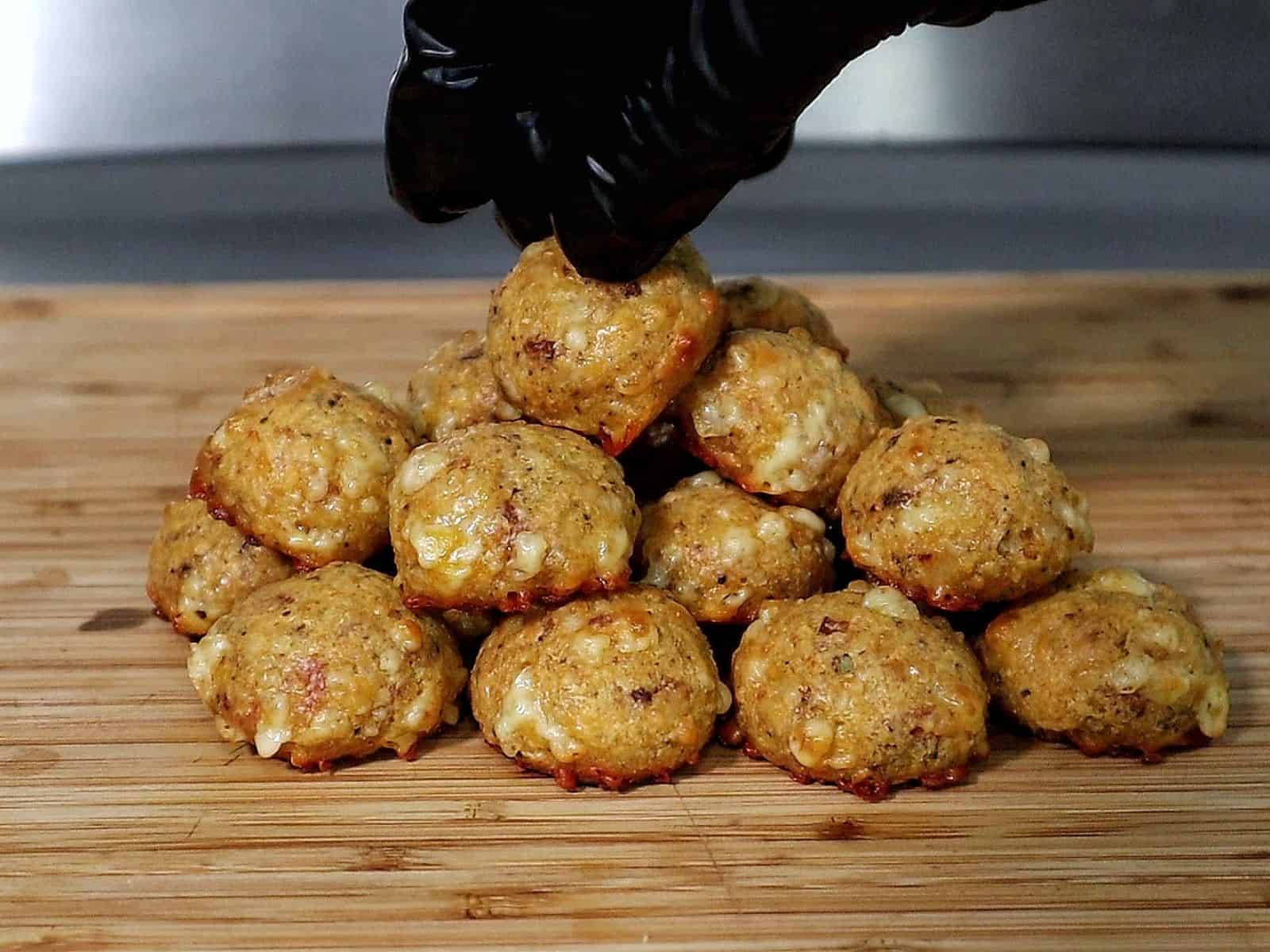 Cheesy Parmesan Mozzarella Bacon Bites stacked on a wooden board, garnished with fresh parsley, showcasing a cheesy, crispy texture.