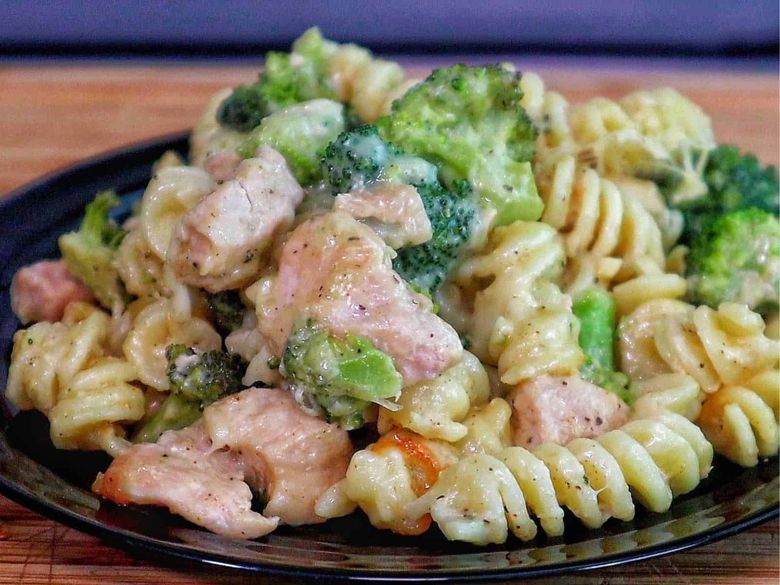 creamy baked pasta filled with rotini noodles, tender chicken pieces, and bright green broccoli, all coated in rich Alfredo sauce and melted cheese.