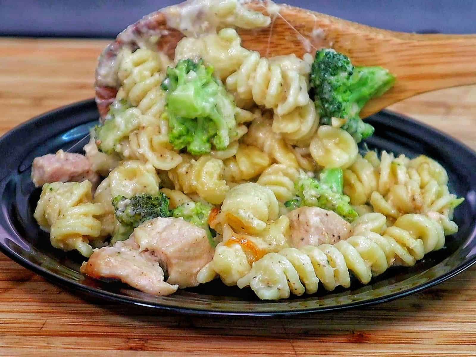creamy baked pasta filled with rotini noodles, tender chicken pieces, and bright green broccoli, all coated in rich Alfredo sauce and melted cheese.