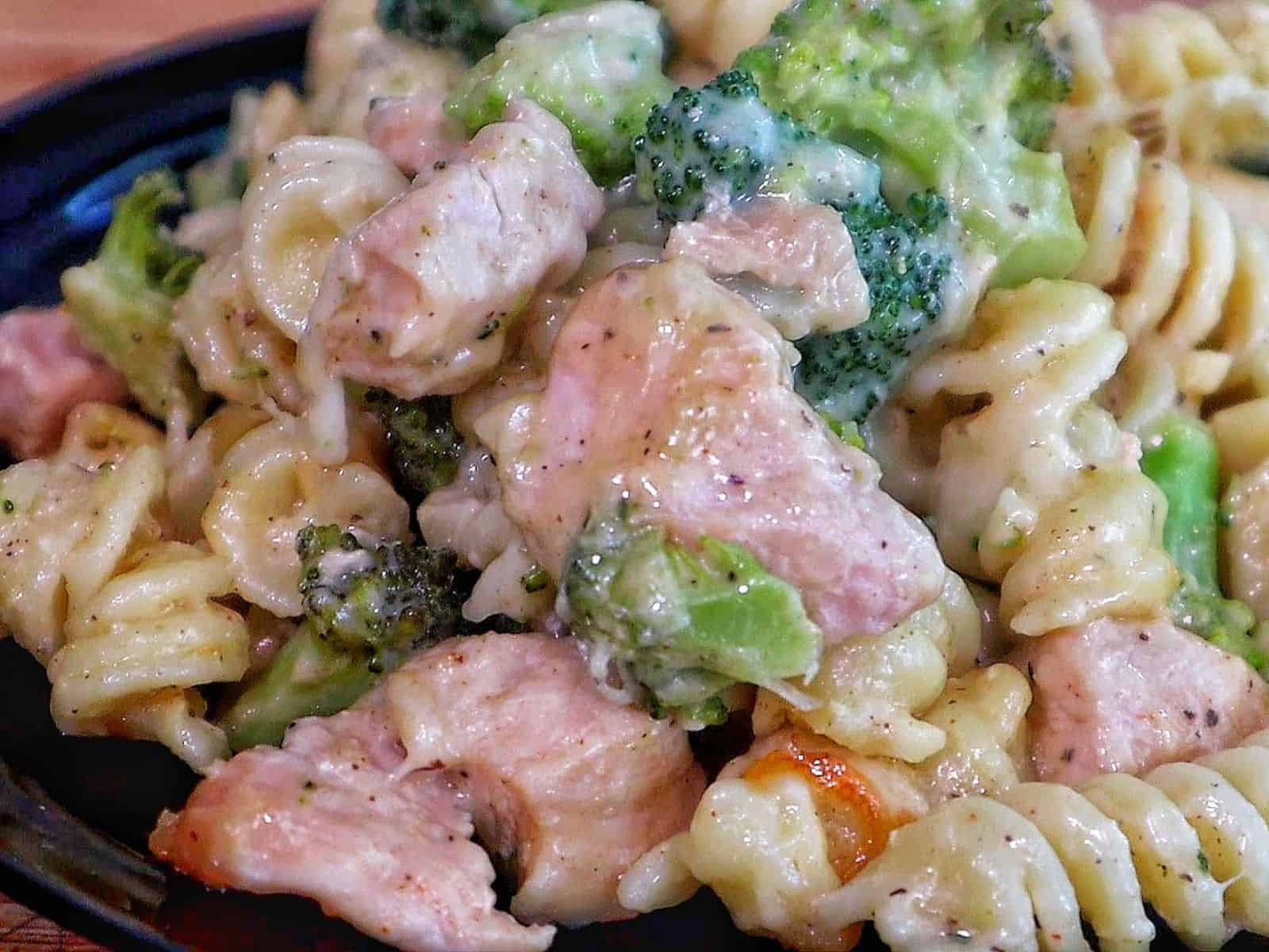 creamy baked pasta filled with rotini noodles, tender chicken pieces, and bright green broccoli, all coated in rich Alfredo sauce and melted cheese.