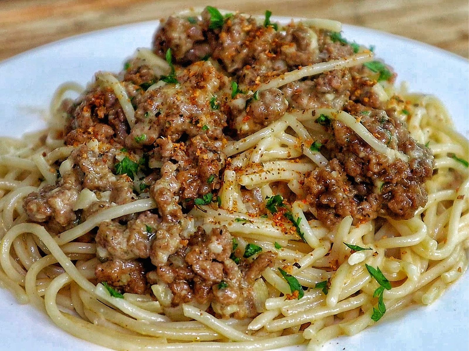 Creamy Cajun beef spaghetti, featuring tender spaghetti noodles coated in a rich, cheesy sauce with seasoned ground beef and sprinkled with fresh parsley.
