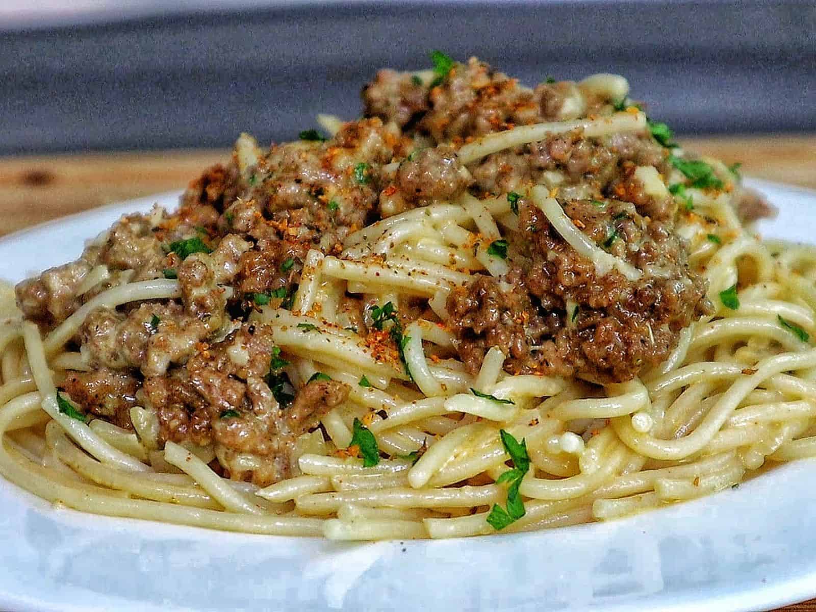 Creamy Cajun beef spaghetti, featuring tender spaghetti noodles coated in a rich, cheesy sauce with seasoned ground beef and sprinkled with fresh parsley.