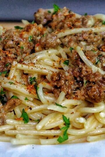 Creamy Cajun beef spaghetti, featuring tender spaghetti noodles coated in a rich, cheesy sauce with seasoned ground beef and sprinkled with fresh parsley.