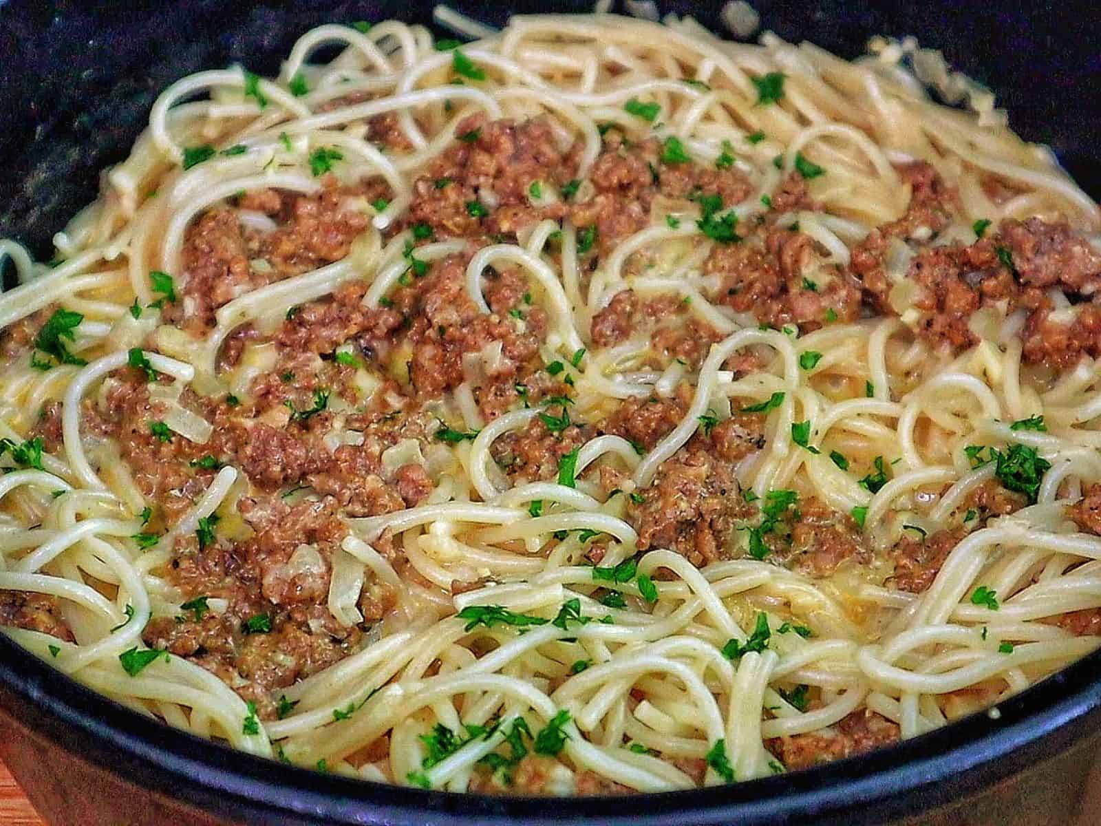 Creamy Cajun beef spaghetti, featuring tender spaghetti noodles coated in a rich, cheesy sauce with seasoned ground beef and sprinkled with fresh parsley.