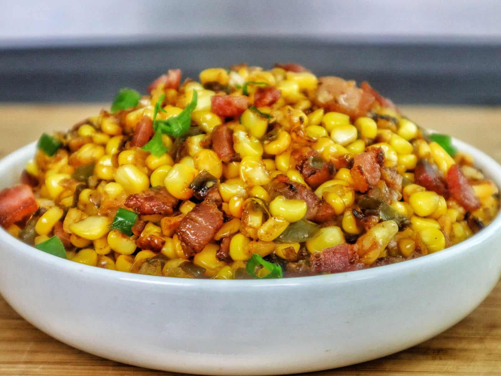 Southern skillet fried corn mixed with crispy bacon, green peppers, onions, and seasonings.