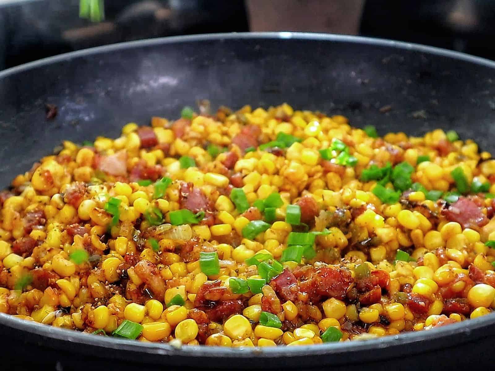Southern skillet fried corn mixed with crispy bacon, green peppers, onions, and seasonings.
