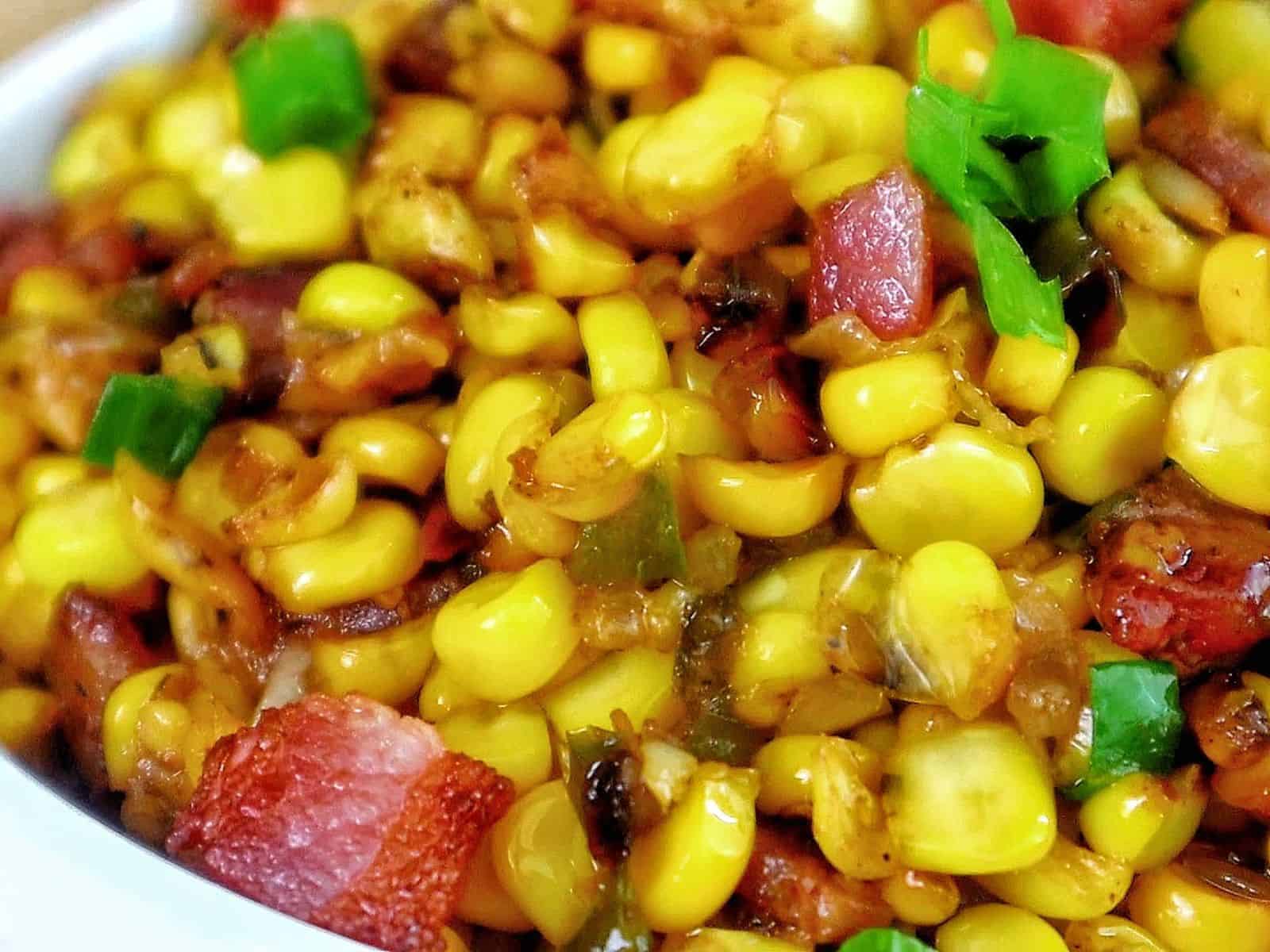 Southern skillet fried corn mixed with crispy bacon, green peppers, onions, and seasonings.