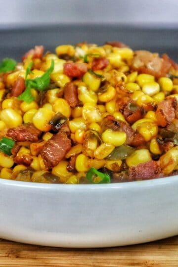 Southern skillet fried corn mixed with crispy bacon, green peppers, onions, and seasonings.