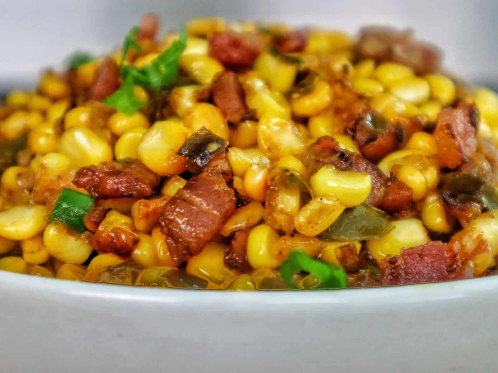 Southern skillet fried corn mixed with crispy bacon, green peppers, onions, and seasonings.