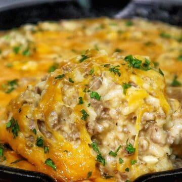 Creamy garlic butter beef and rice skillet topped with melted cheddar and parsley