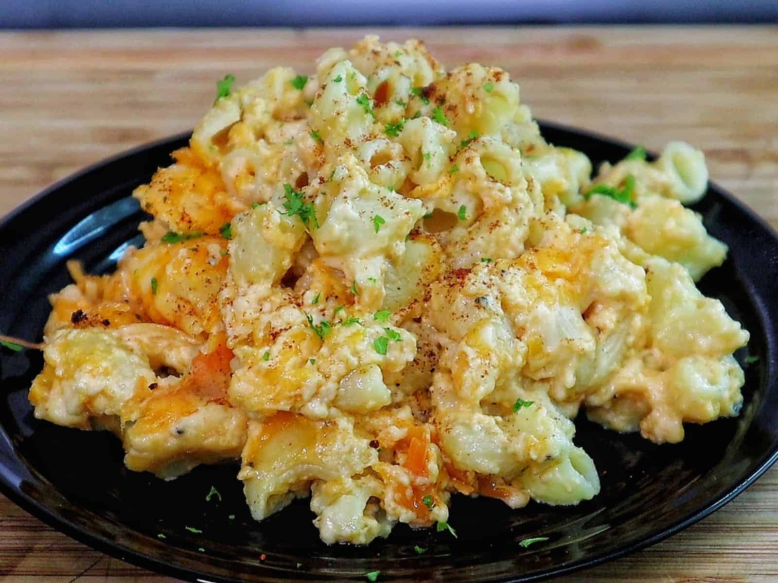 Creamy slow cooker mac and cheese topped with melted cheddar and herbs, showing tender elbow noodles coated in a rich, golden cheese sauce.