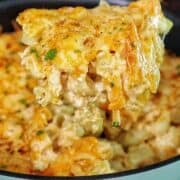 Creamy slow cooker mac and cheese topped with melted cheddar and herbs, showing tender elbow noodles coated in a rich, golden cheese sauce.