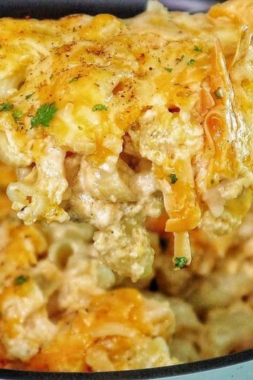 Creamy slow cooker mac and cheese topped with melted cheddar and herbs, showing tender elbow noodles coated in a rich, golden cheese sauce.