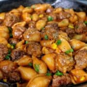 Cheddar BBQ ranch meatball pasta in a skillet with shell pasta, tender meatballs, creamy BBQ ranch sauce, melted cheddar cheese, sweet corn, and green onion garnish.