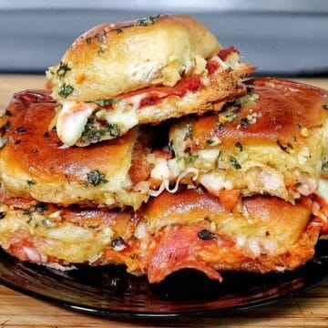 Pull-apart pizza sliders made with Hawaiian rolls, layered with melted mozzarella, pepperoni, pizza sauce, and brushed with a garlic herb butter topping.